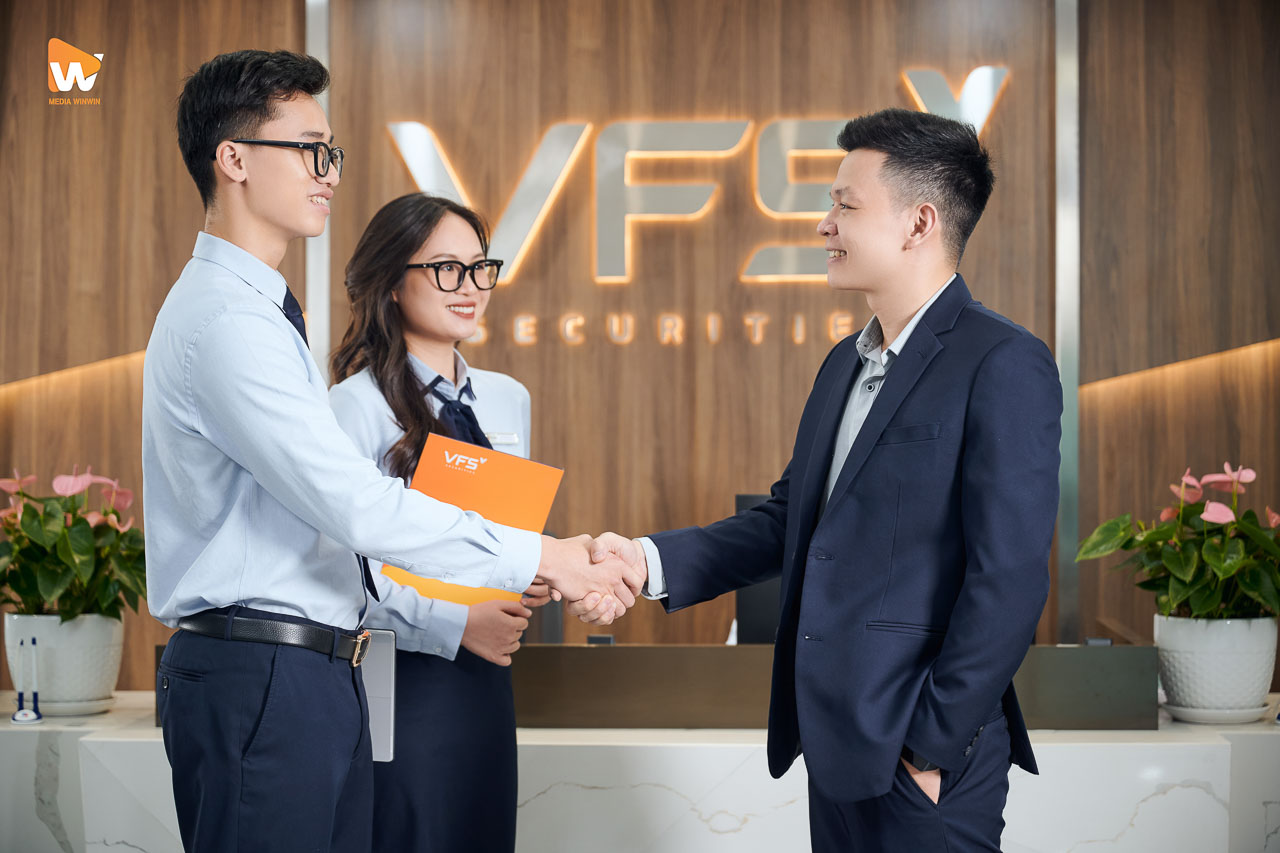 Nhân viên VFS Securities bắt tay trao hồ sơ cho khách hàng
